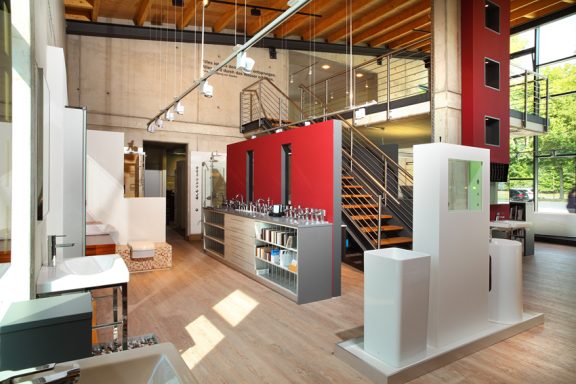 Modern Innenraum mit Holzdecken, roten Wänden und einer Treppe im Hintergrund.