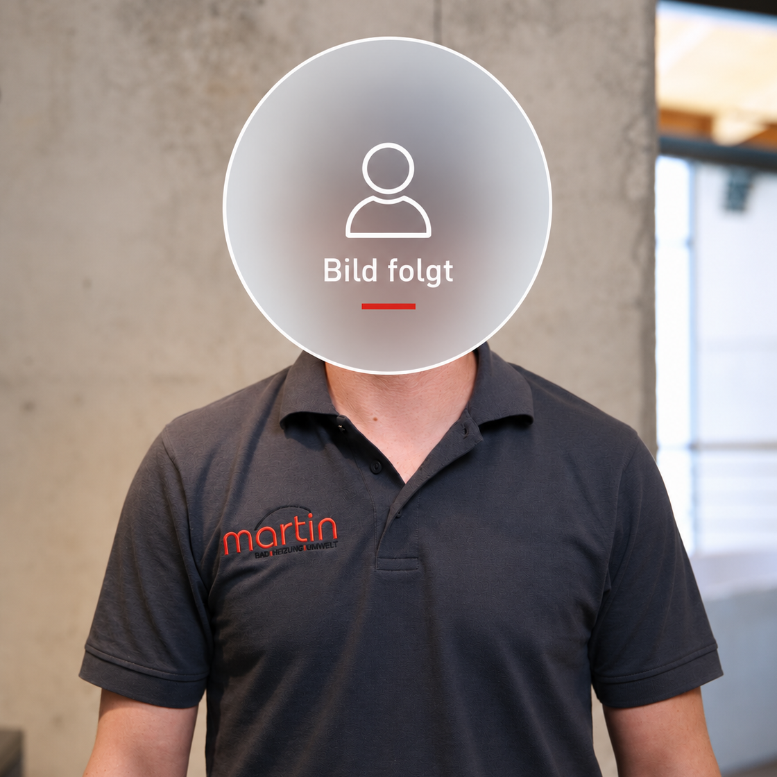 Lächelnder Mann mit Brille, trägt ein dunkelgraues Polo-Shirt mit Logo.