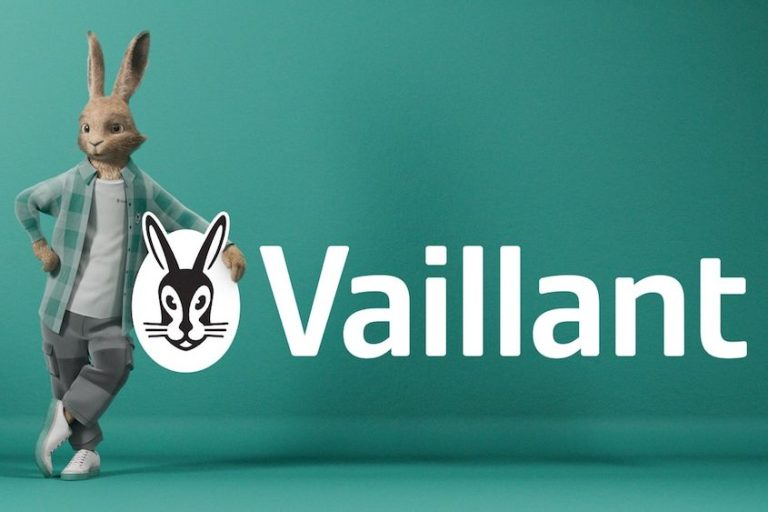 Hase mit Kleidung steht vor einem einfarbigen Hintergrund und dem Schriftzug "Vaillant".